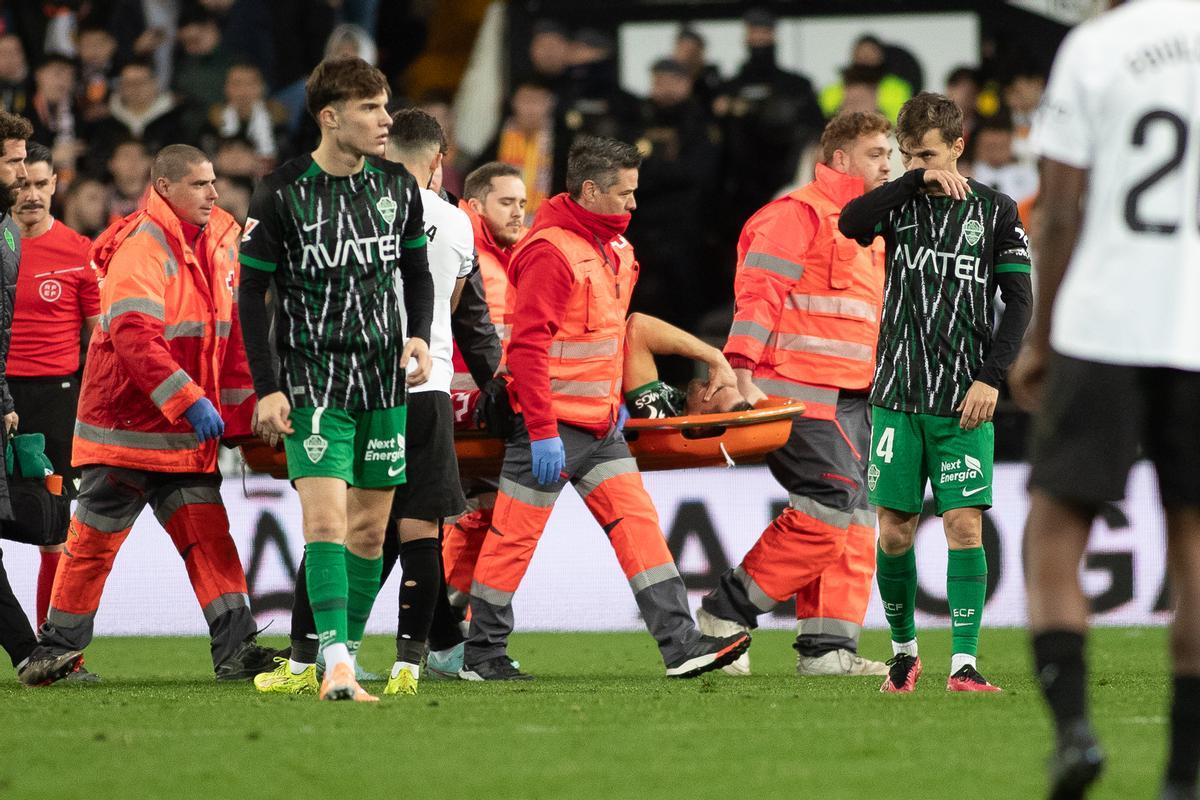 Pedro Bigas abandona Mestalla en camilla tras el choque con Lucas Beltrán.