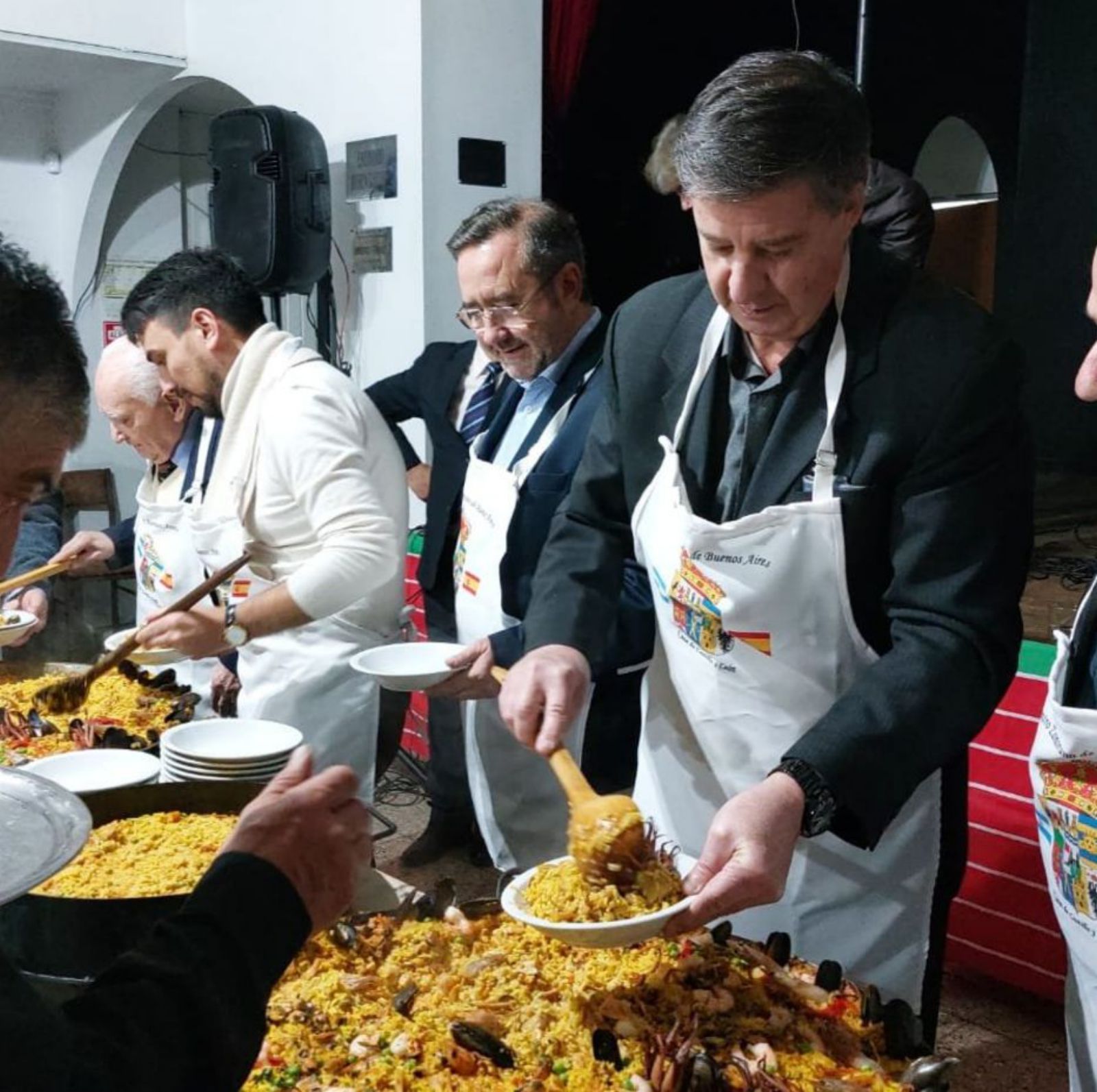 El presidente, Alfredo Miranda, sirviendo paella a los comensales.