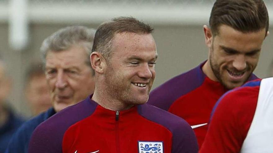 Rooney (centro) sonríe en el entrenamiento de Inglaterra, con el seleccionador Hodgson tras él. // Lee Smith