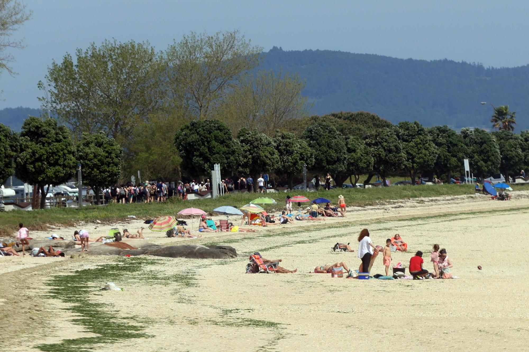 Arousanos y turistas disfrutan en las playas de un anticipio del verano.