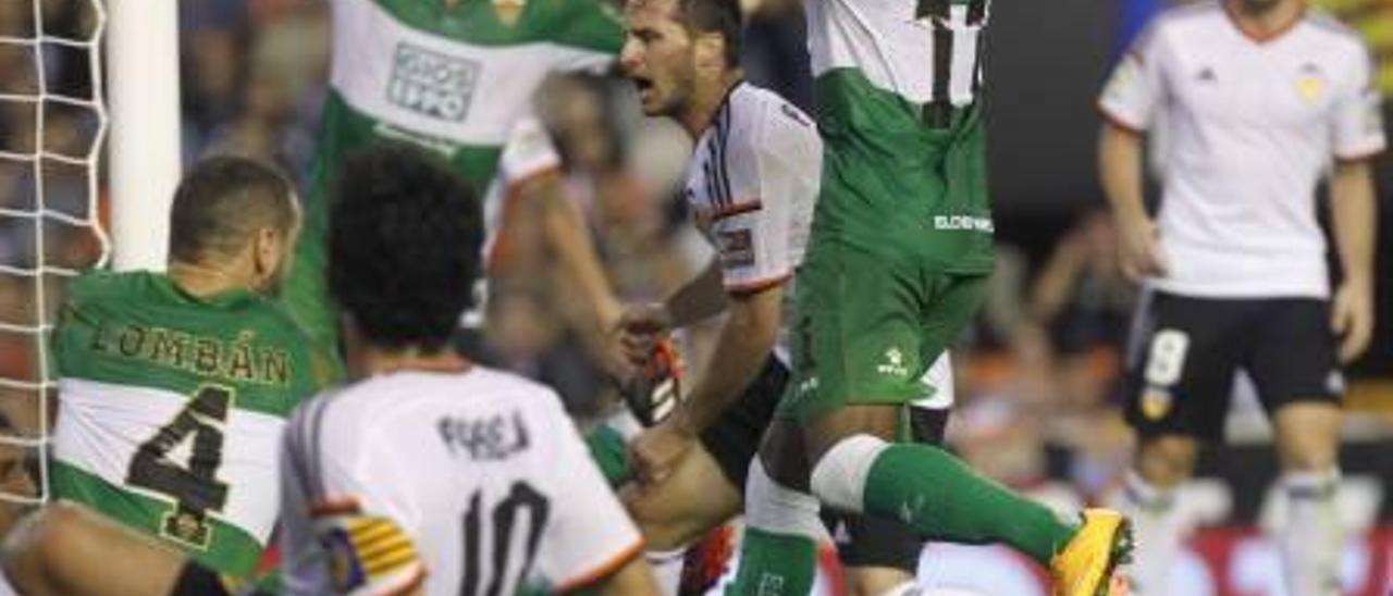 Lombán, en el suelo, y Garry Rodrigues y Domingo Cisma levantan las manos ante varios jugadores del Valencia.