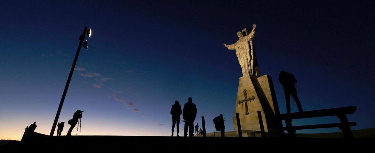 Varios visitantes observan el atardecer desde el Sagadro Corazón, en el Naranco.