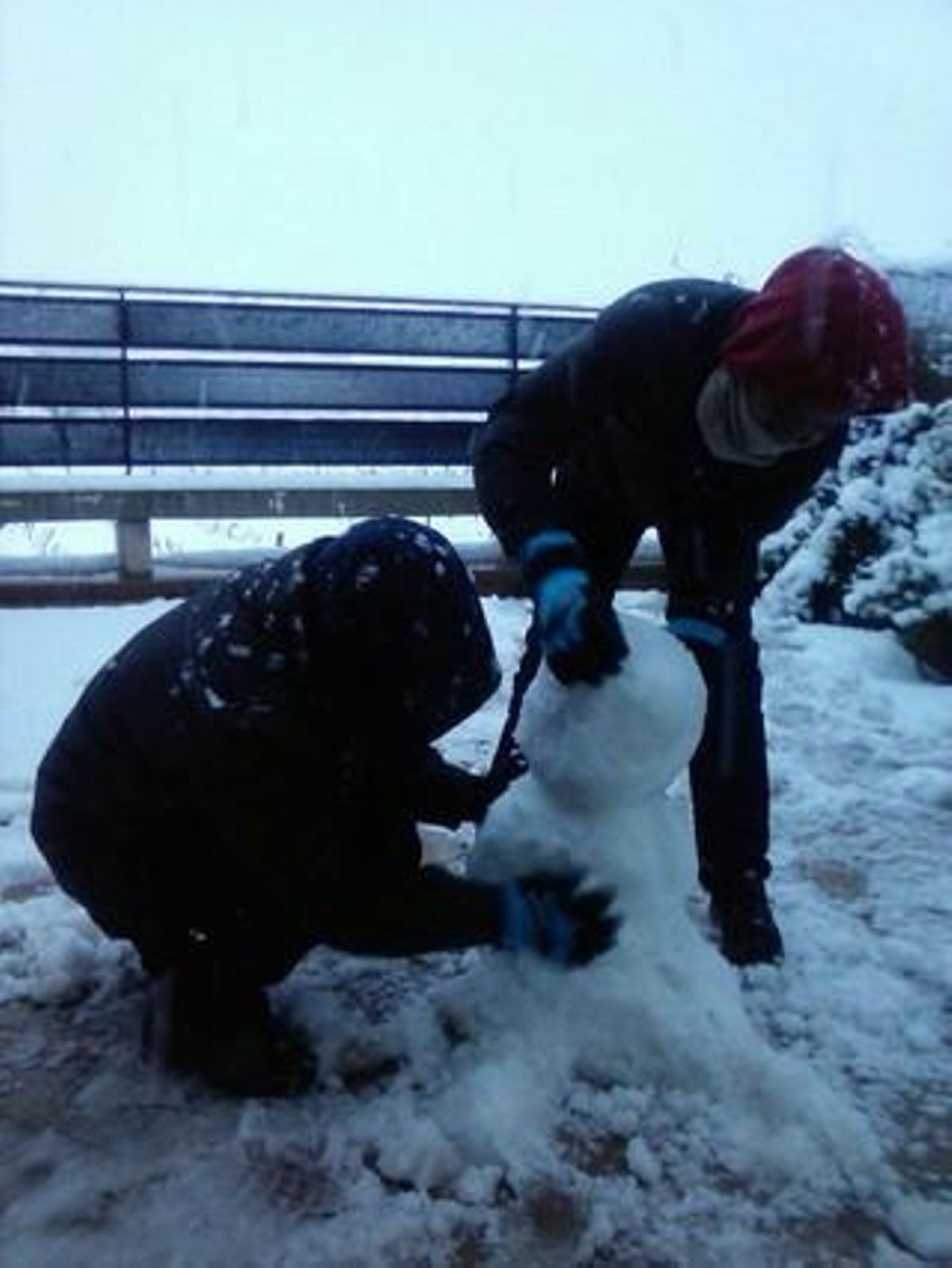 Dos escolars fan un ninot de neu, aquest matí, a Santa Margarida i els Monjos (Alt Penedès).