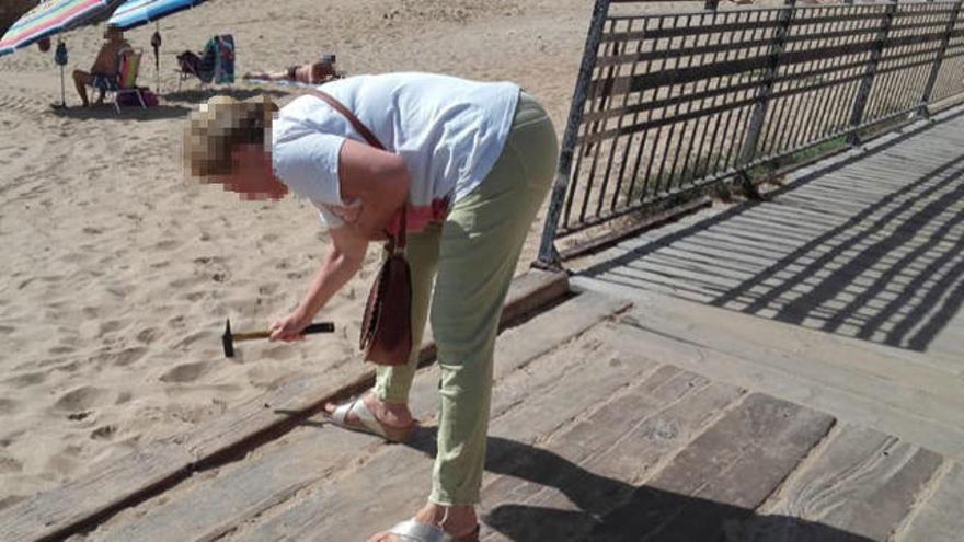 Una vecina de La Mata apuntala los tablones del paseo