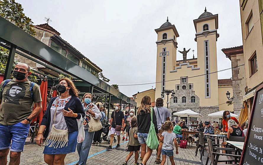 Ambiente durante el mercado de los miércoles en Ribadesella, con la iglesia de Santa María Magdalena al fondo. | Irma Collín