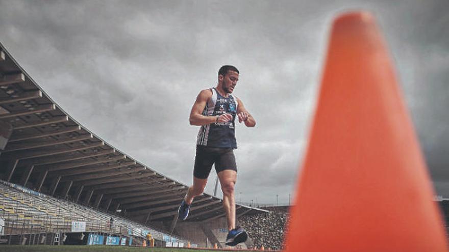 Un atleta del Tenerife CajaCanarias mira el crono durante su entrenamiento en el CIAT de Tíncer.