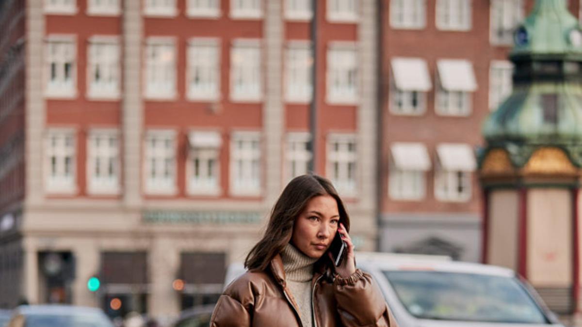 Look con plumífero y pantalones rectos blanco roto, en el 'street style' de Copenhague