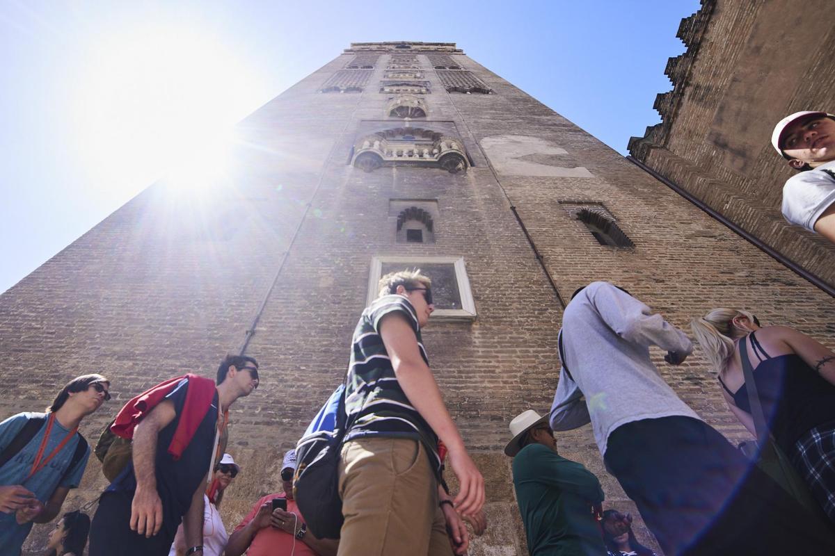 Un grupo de turistas junto a la Giralda.