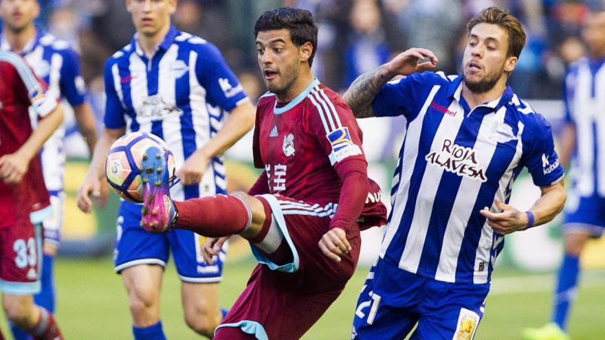 Vela, de la Real Sociedad, controla el balón ante Femenía, del Alavés.