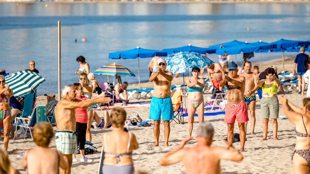 Turistas del Imserso haciendo gimnasia en la playa de Levante de Benidorm la pasada primavera