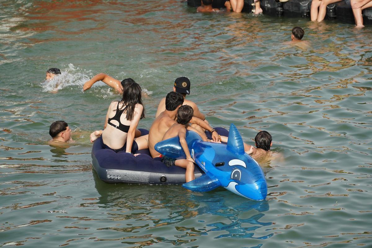 La 'cucaña', el juego centenario que regresa cada verano al río Guadalquivir por la Velá de Santa Ana en imágenes