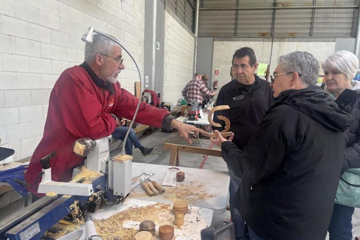 Cristóbal Bergillos, a la izquierda, explica el proceso de elaboración de una pieza a tres visitantes.