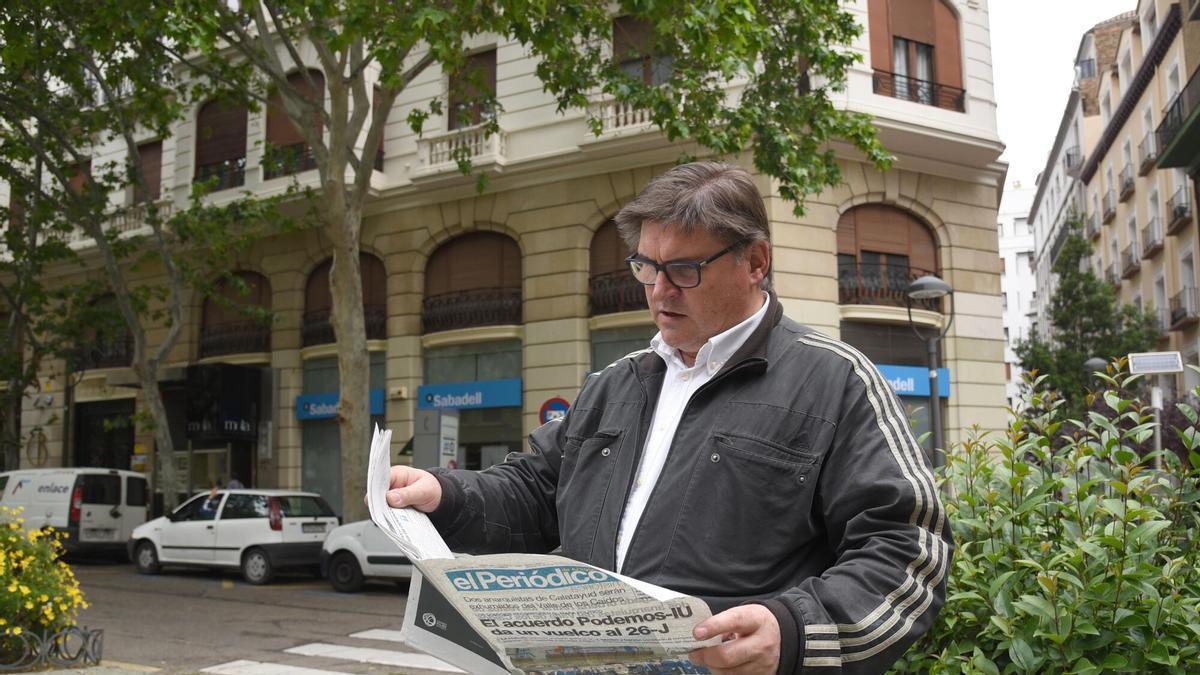 Un hombre leyendo un periódico en la plaza Santa Engracia de Zaragoza.
