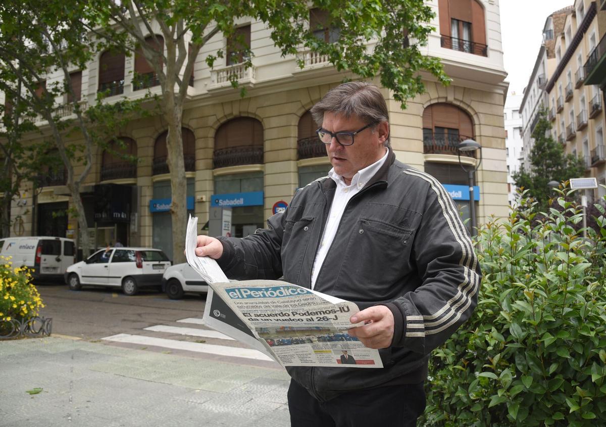 Un hombre leyendo un periódico en la plaza Santa Engracia de Zaragoza.