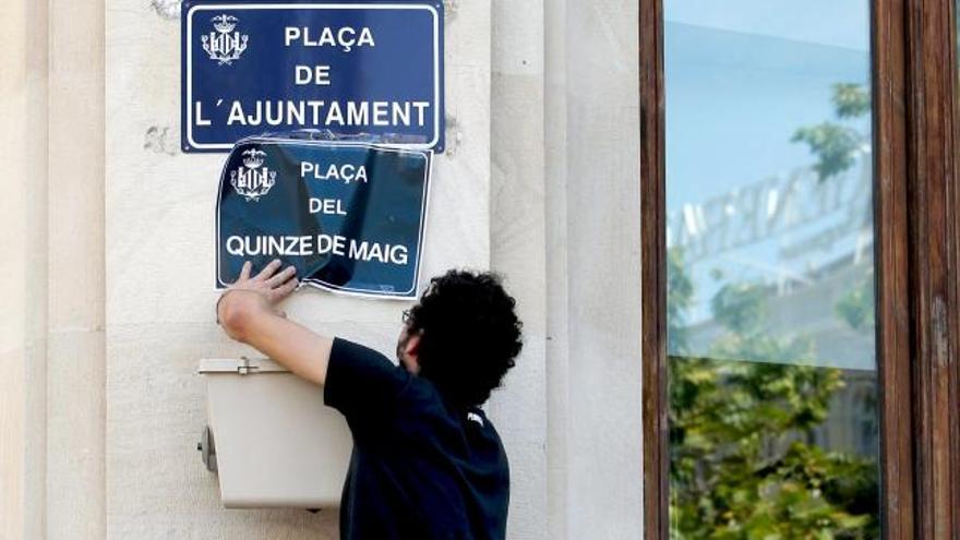 Varios jóvenes han sustituido la placa que da nombre a la plaza del Ayuntamiento por una que simbólicamente pone &quot;Plaza del 15 de mayo&quot;