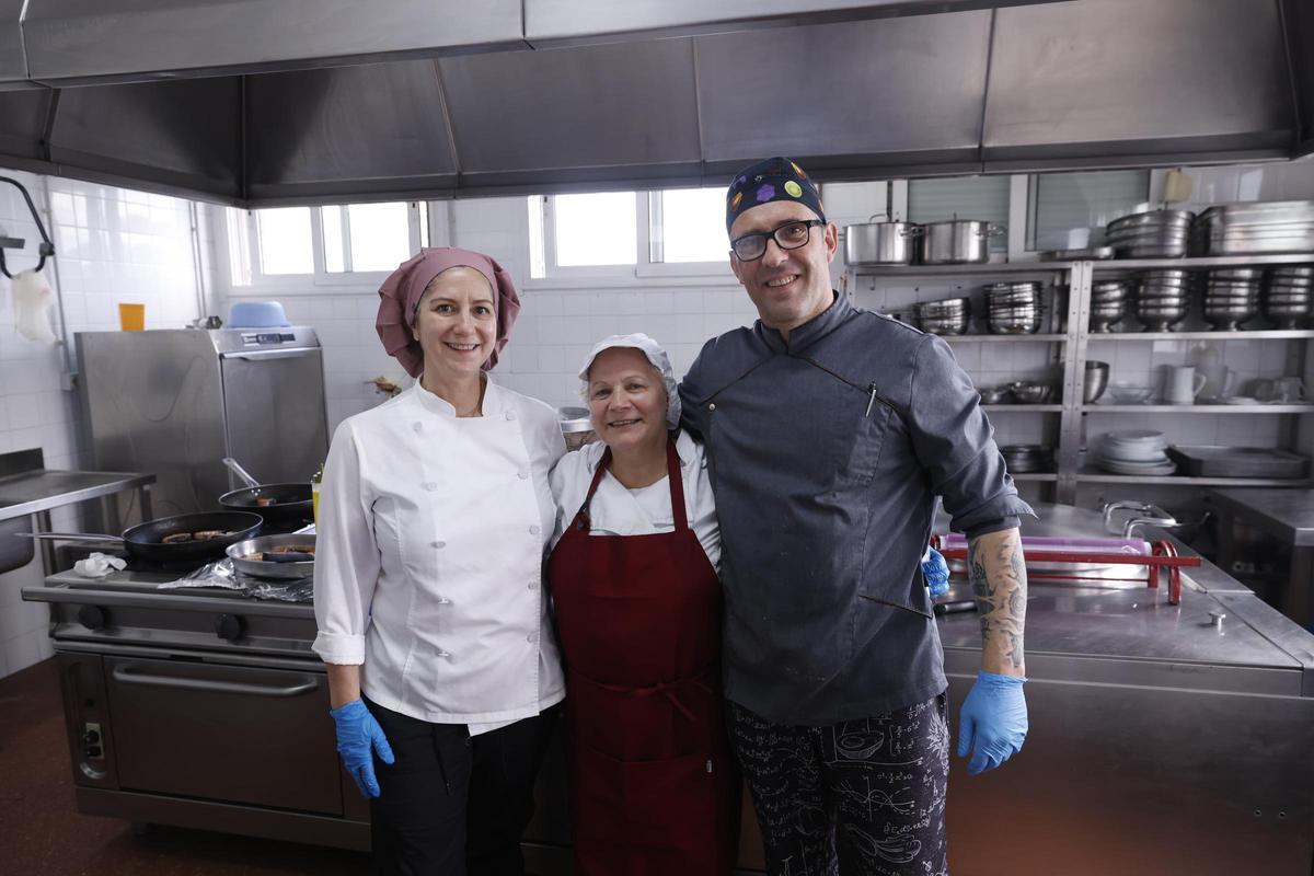 Mari Luz Cruces, en el centro, junto a Laura García y Óscar López, sus compañeros en la cocina del colegio.