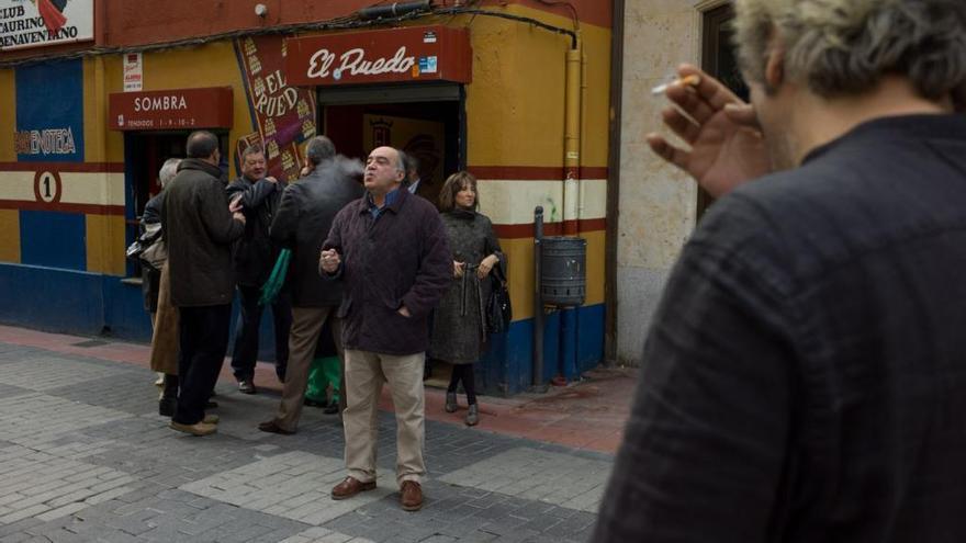 Varias personas fuman en la calle.