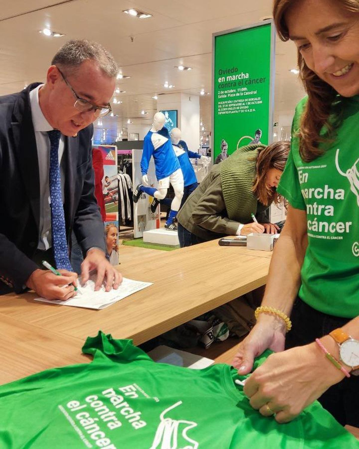 El consejero Pablo Fernández, inscribiéndose en la carrera contra el cáncer, en Oviedo.