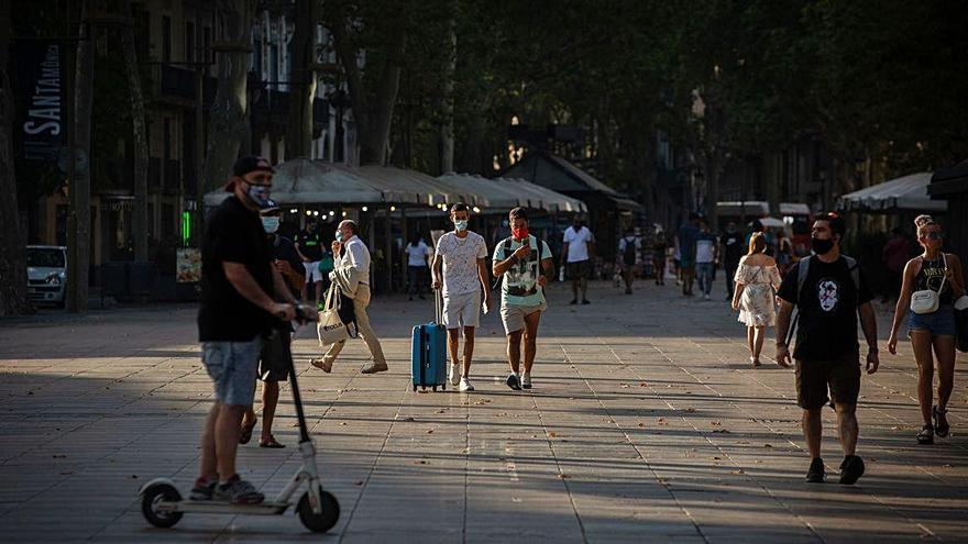 Un turista camina amb la maleta per la Rambla de Barcelona