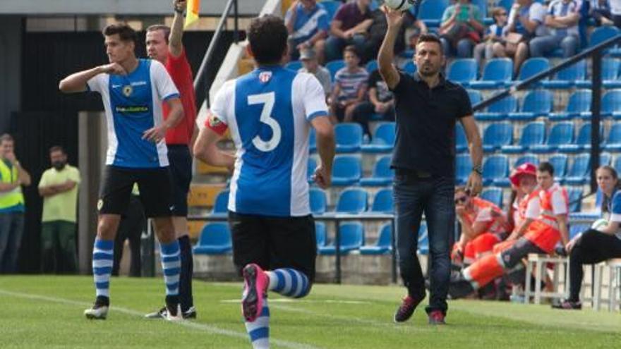 Manolo Herrero, técnico del Hércules, se dispone a dar el balón a Peña, durante un partido en el Rico Pérez.