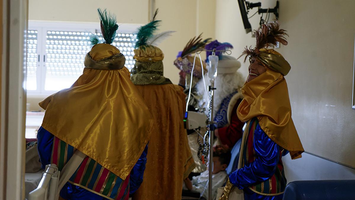 Sus Majestades los Reyes y sus pajes en la visita al Hospital Macarena la Navidad de 2024.