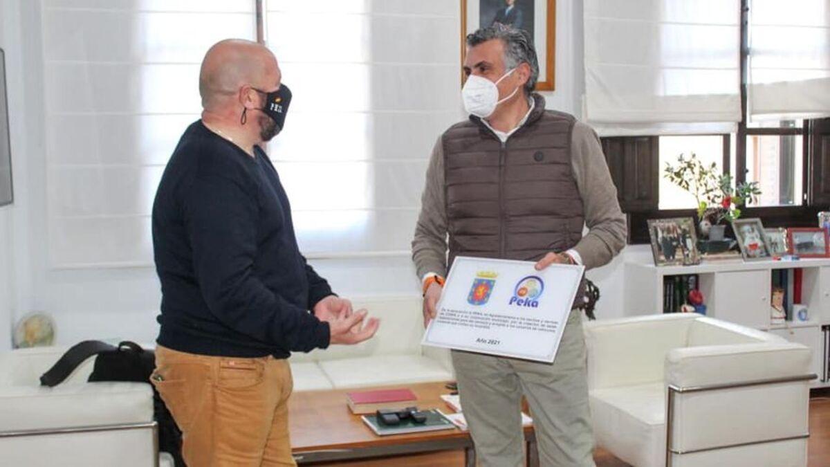 El alcalde de Coria recibe de manos de un representante de la Plataforma Karavaning, una placa en señal de agradecimiento.