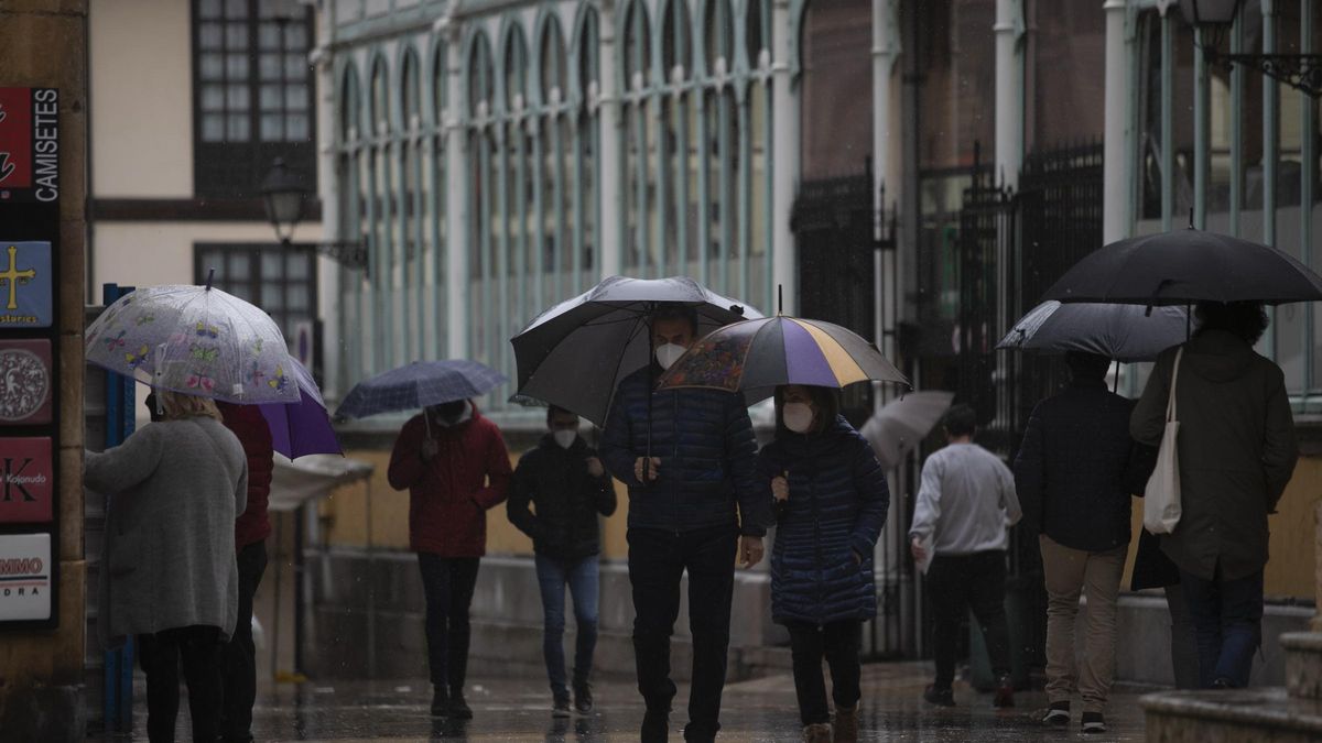 Gente en Oviedo paseando bajo la lluvia. MIKI LÓPEZ