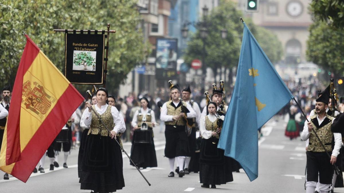 La banda de gaitas «El Carbayón» recorre la calle Uría en el desfile folclórico.