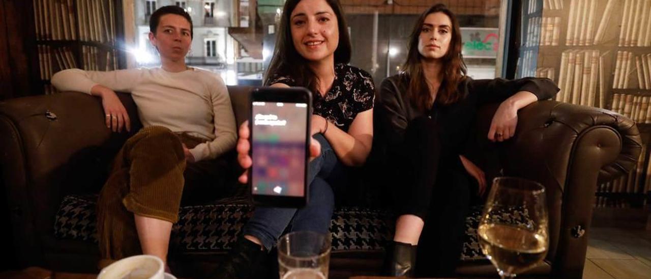 Jimena Escudero con la pantalla de un smartphone con su asistente inteligente activado, sentada entre Elvia Vasconcelos, a la izquierda, y Harriet Smith Hughes, ayer, en Oviedo.