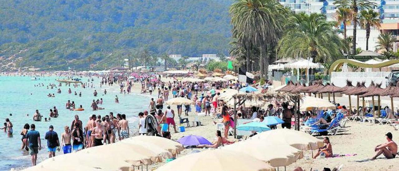 Turistas disfrutan de Platja d’en Bossa este verano. | J.A.RIERA