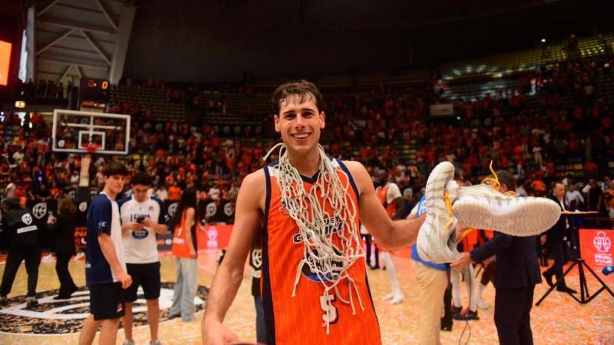 Guillem Jou, con sus zapatillas y la red de una canasta tras conseguir el ascenso a la Liga ACB en el Coliseum