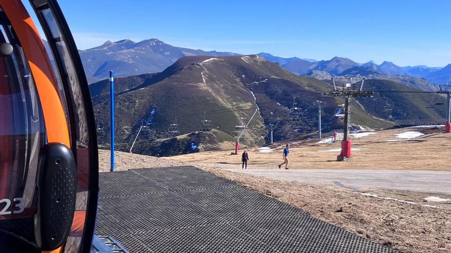 Visitantes ayer en la estación de Pajares, junto a la telecabina, con las pistas sin apenas nieve.