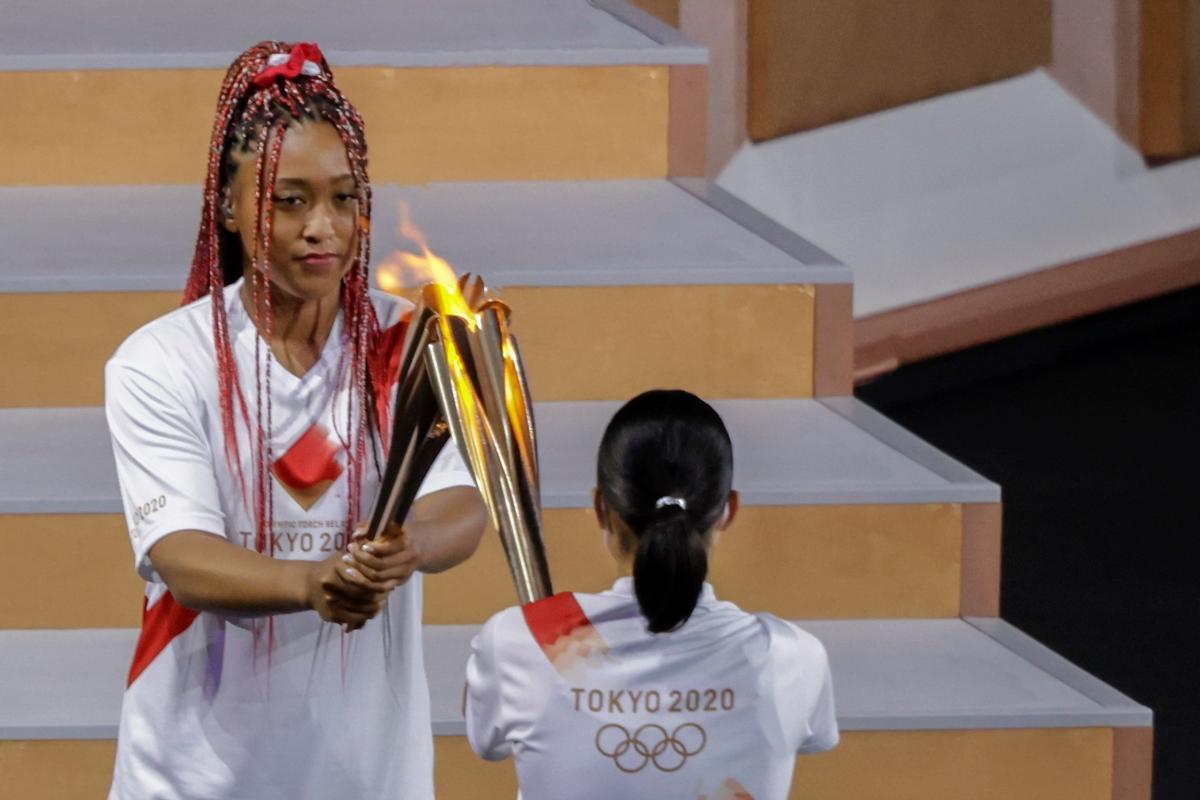 La tenista japonesa Naomi Osaka recibe el último relevo de la Antorcha Olímpico durante la ceremonia inaugural de los Juegos Olímpicos de Tokio 2020.