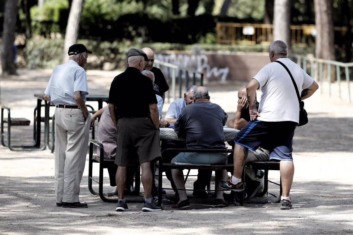 Varios pensionistas juegan al dominó en un parque de Madrid.