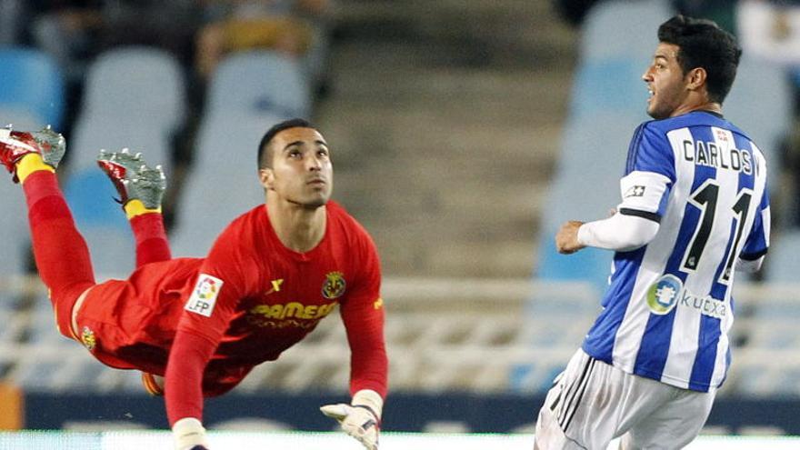 El portero del Villarreal Asenjo despeja un balón ante Carlos Vela.