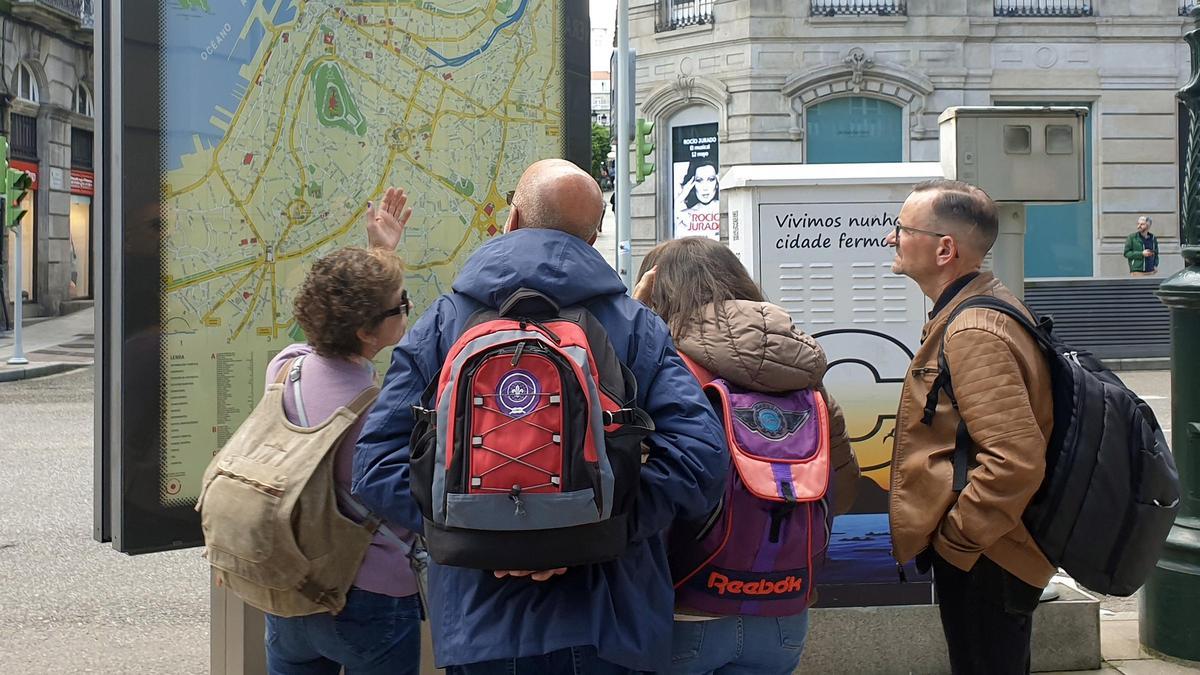 Turistas portugueses ante un mapa de la ciudad de Vigo