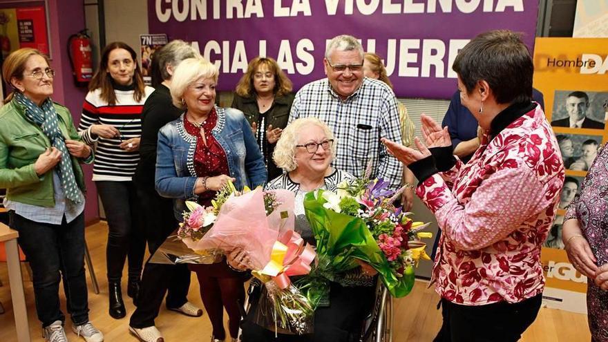 Socias de AMDAS entregan dos ramos de flores a Sila Murillo, junto a su marido, ayer, en la Casa de Encuentros de la Mujer.