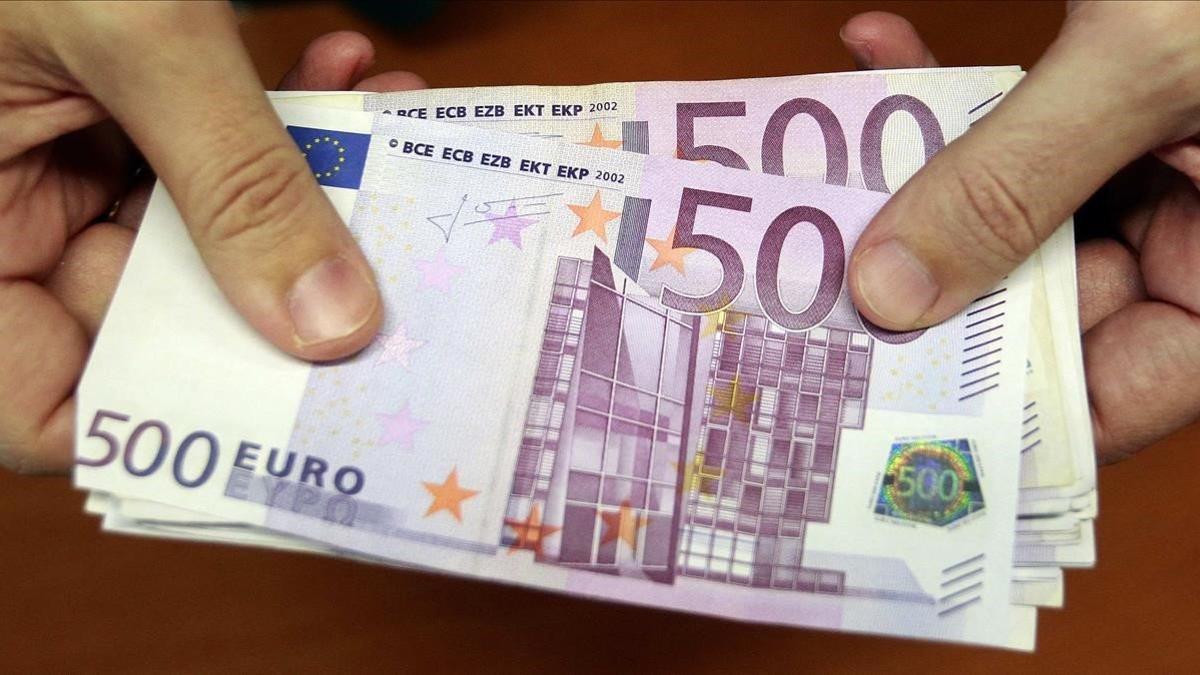 zentauroepp14910387 a bank employee holds a pile of 500 euro notes  at a bank br190117163239