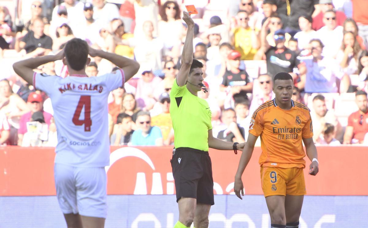 El colegiado muestra una cartulina en el partido de la jornada 37 de LaLiga que Sevilla FC y Real Madrid disputan este domingo en el estadio Sánchez-Pizjuán, en Sevilla. EFE/Raúl Caro. (Sevilla) (Real Madrid)