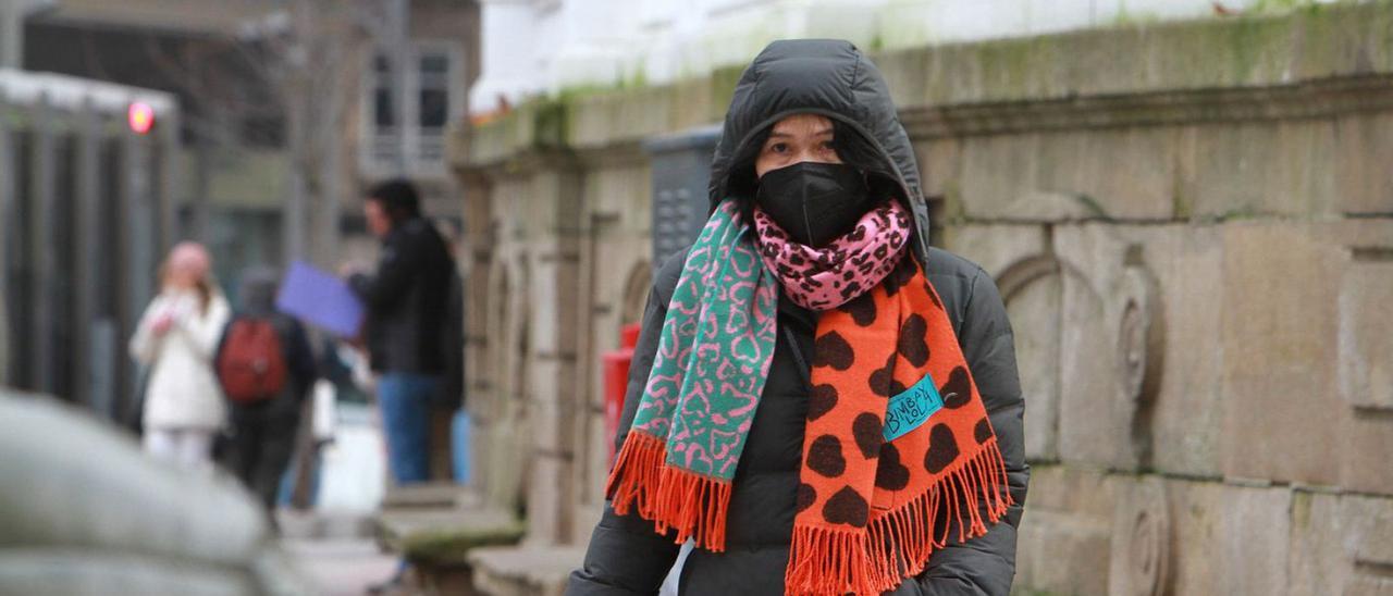 Una mujer camina por Ourense abrigada para protegerse del frío.   | // IÑAKI OSORIO