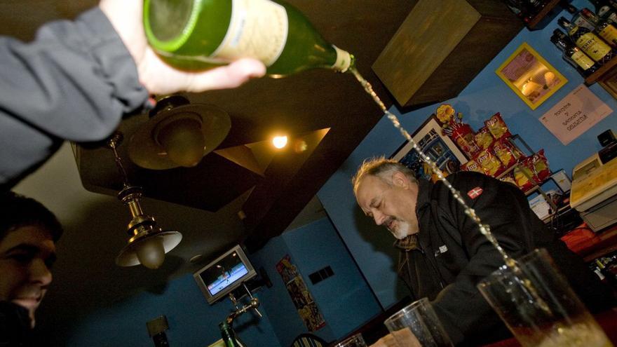 Un hombre sirve sidra del País Vasco en un bar de Astigarraga (Guipúzcoa). | Miki López