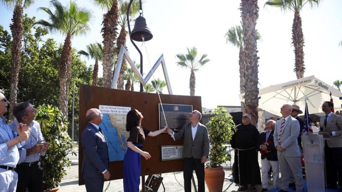 Cruz Sánchez de Lara y Elías Bendodo tocan la campana del Memorial a José de Gálvez, en el Puerto, en presencia de Carlos Rubio.