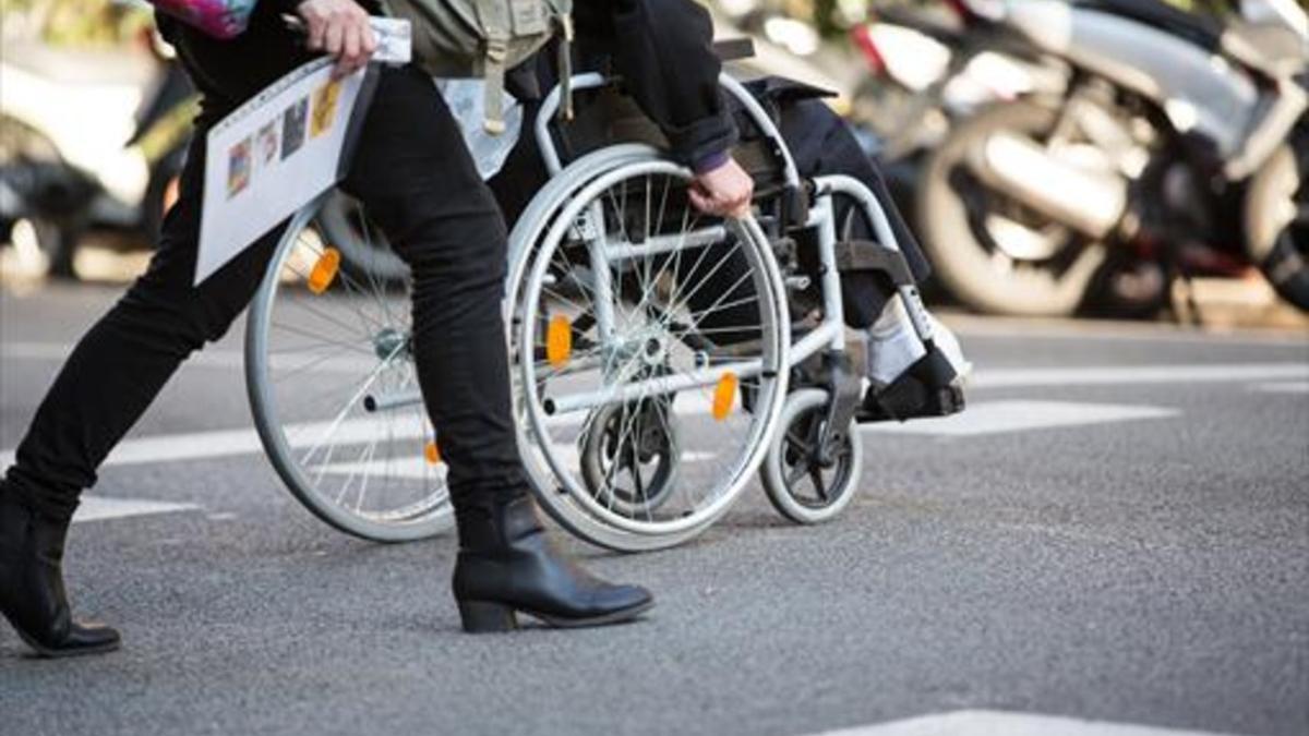 Una persona en silla de ruedas, por las calles de Barcelona.
