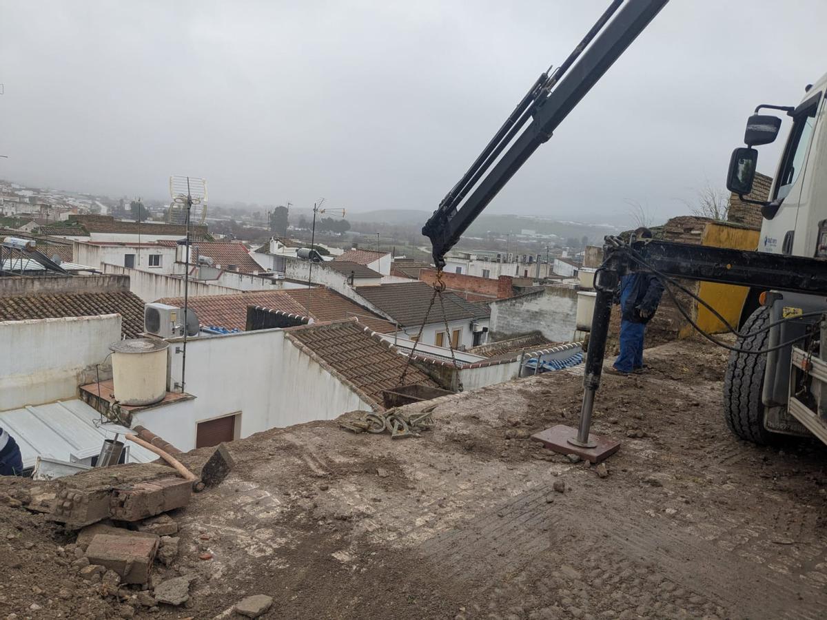 Una máquina trabaja en la retirada de material de la muralla desprendido.