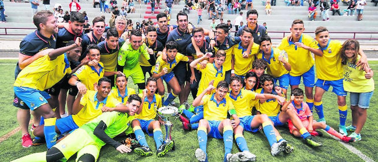 La amplia plantilla del infantil &#039;A&#039; de la UD Las Palmas posa con el trofeo de campeón absoluto como culminación de la temporada.