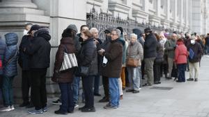 Numerosas personas hacen cola ante el Banco de España para comprar deuda pública. EFE/ Javier Lizon
