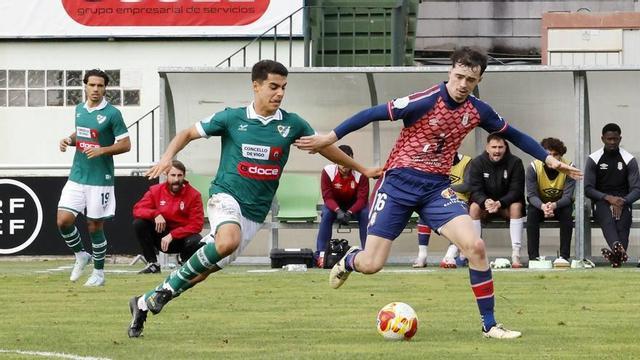 Un jugador del Coruxo presiona a un rival durante un partido de Liga
