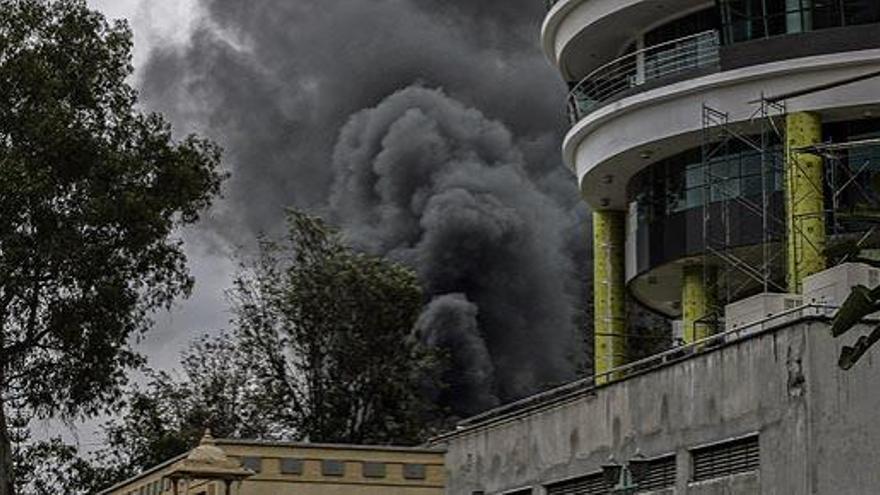 Una columna de humo en el centro comercial, ayer.