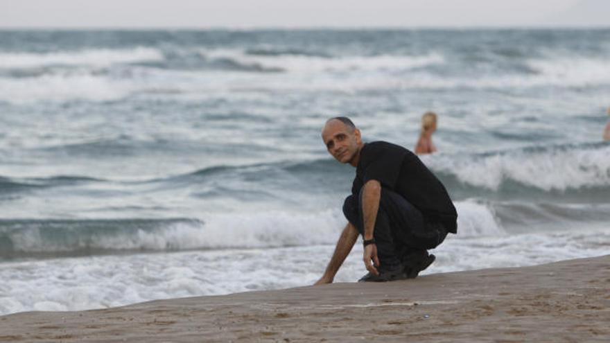 José Luis García Paneque, preso cubano liberado, toca la arena de la playa de Cullera, ciudad a la que ayer llegó desde Madrid para recalar en su centro temporal de refugiados.