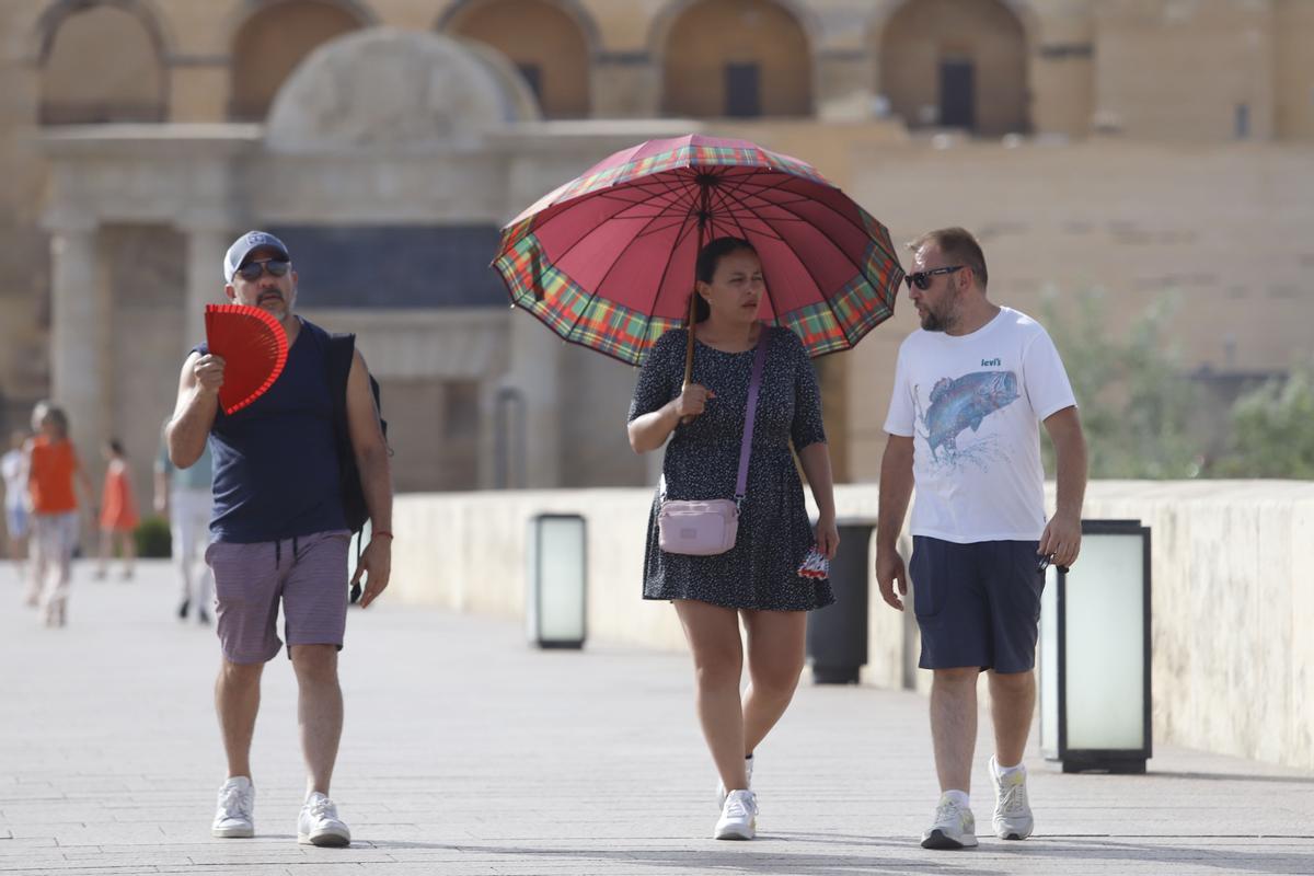 Una turista se protege del sol con un paraguas.